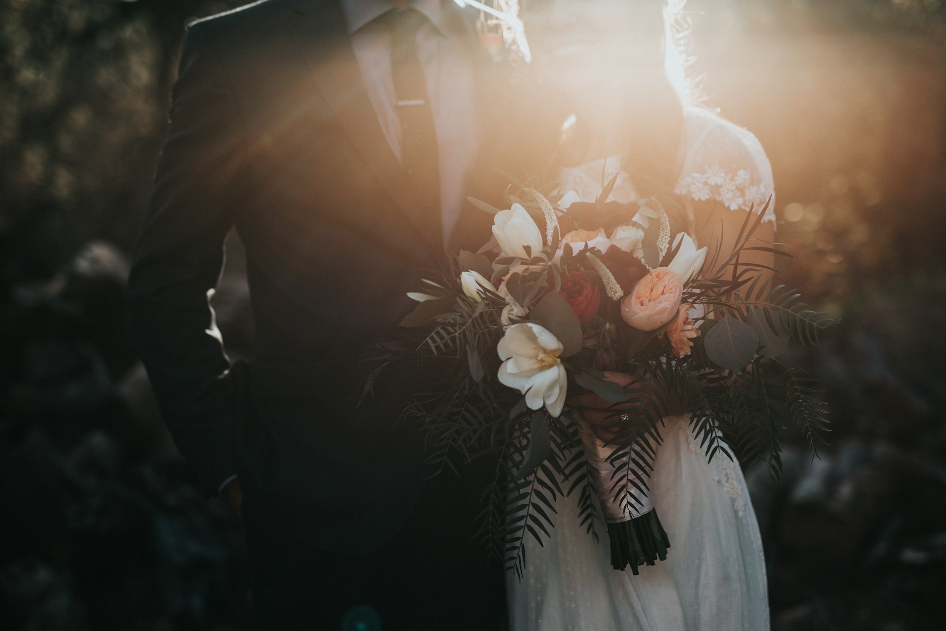 Close-up of a couple's hands with wedding rings, softly lit